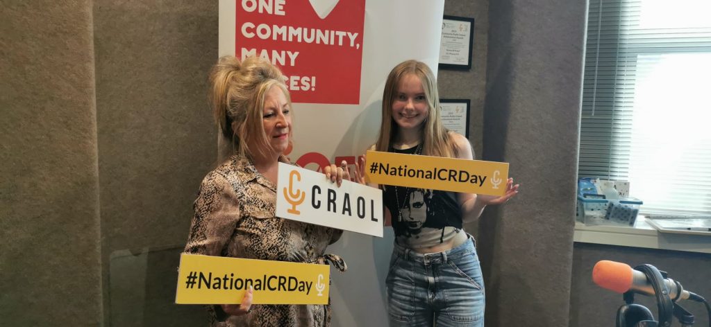 Two women stand in the 92.5 Phoenix FM studio promoting CRAOL's National Community Radio Day.