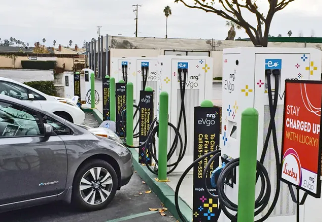 Two cars parked at an electric car charging station.